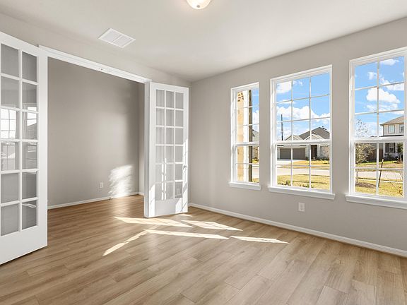 Quietly nestled in the front of the home, the office features large windows and beautiful French doo