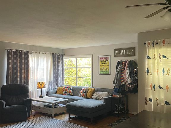 Large open living/dining space with wood burning fire place and lots of natural light.