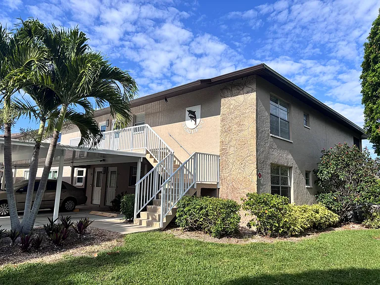 Front of building showing top right hand end unit of this lovely condo overlooking the pool and canal with your own boat dock!