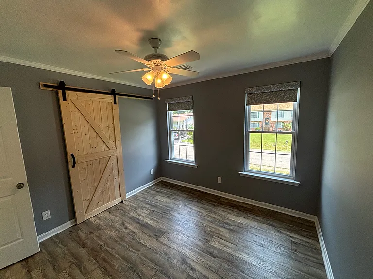 Spare bedroom. Ceiling fan. Sliding barn door on closet.