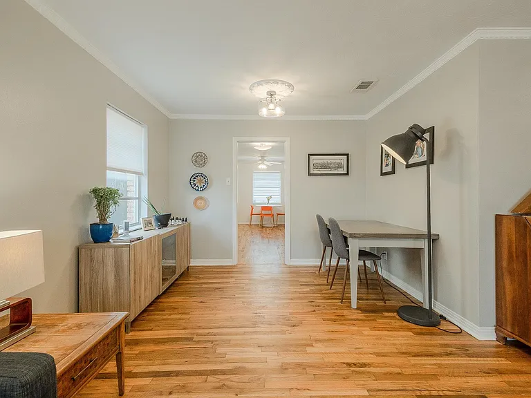 Kitchen has been updated with marble countertops, stainless steel tile backsplash, Jenn-Air gas cooktop with downdraft exhaust, and a GE Profile dishwasher.
