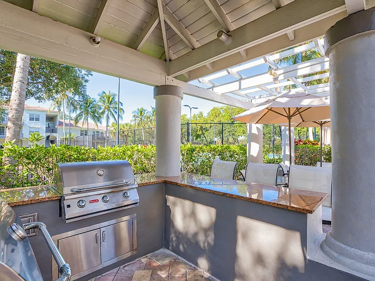 Outdoor grilling area with ample gathering space and shaded areas