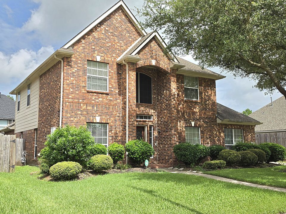 Stunning two-story brick home with mature trees and manicured landscaping
