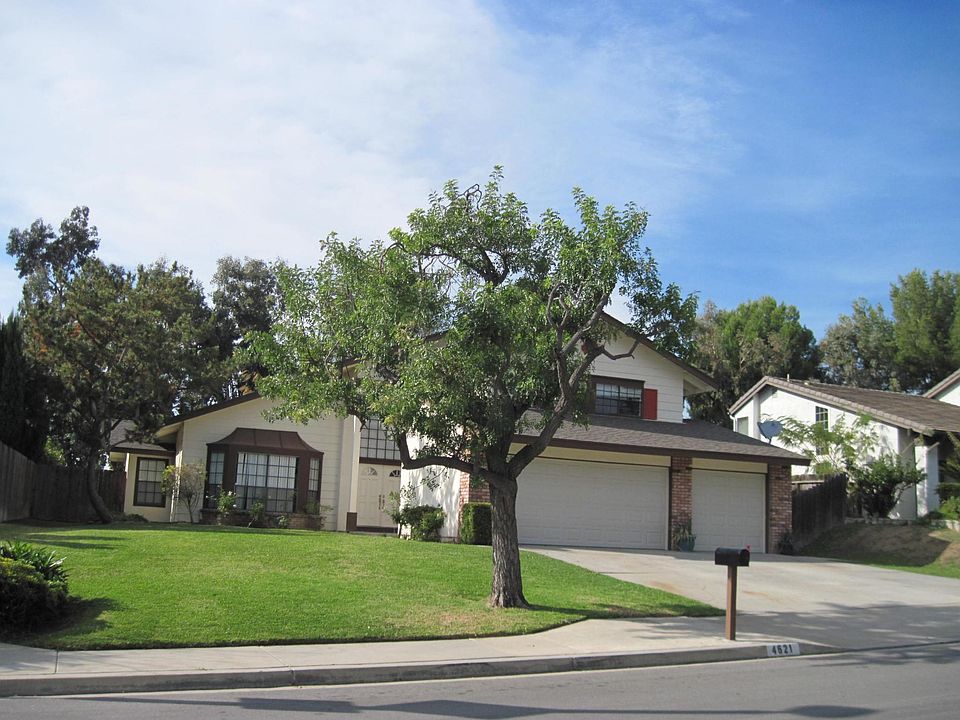 Front entry has white roses lining walkway and in front of bay window