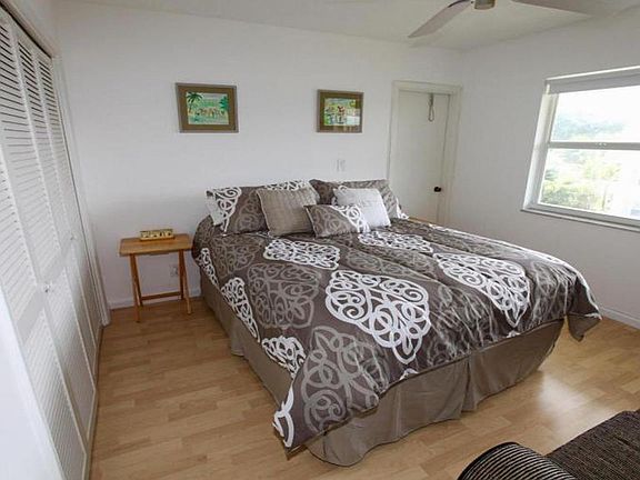 Guest bedroom with Queen size bed and views of the pool area.