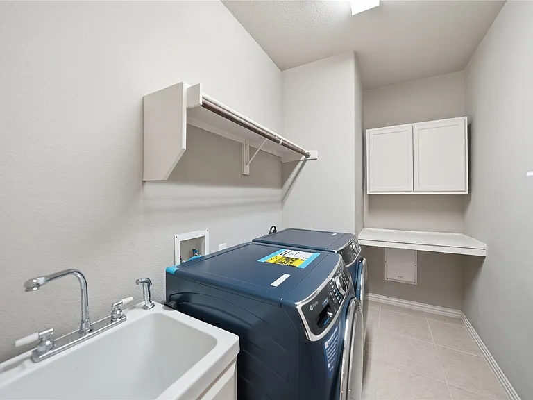oversized laundry room with sink and cabinets