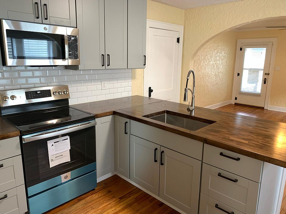 Dark butcher block counters, stainless appliances and dove gray cabinets provide some modern flair in this historic home.