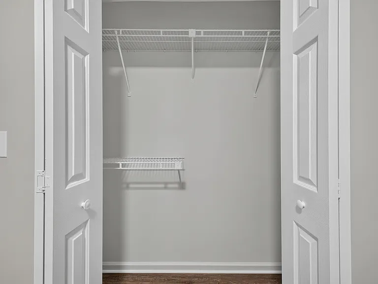 Dedicated closet storage with double doors, a full-length hanging rod, and wire shelving for easy organization.
