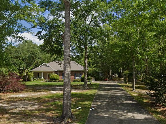 Charming one-story home nestled on a tranquil, tree-lined 1-acre lot with a long, private driveway_offering a peaceful retreat close to the heart of Pass Christian.