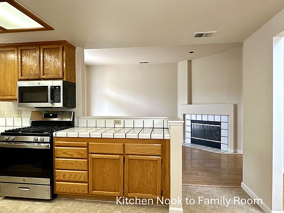 All brand new Kitchen Appliances: Microwave Oven, Gas Range, Stainless Steel Sink, Dishwasher, Refrigerator, and Lighting Fixtures. Photo taken from Nook Area towards the Family Room