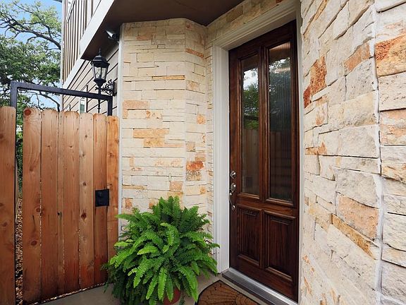 Stacked stone entry with solid wood door. Camera system stays with home as well.