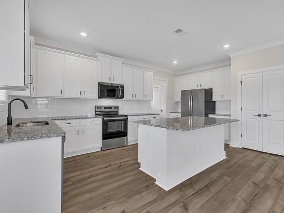 The kitchen has designer wood cabinetry.