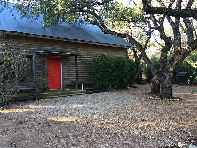Tranquil fenced yard surrounded by large oak trees.