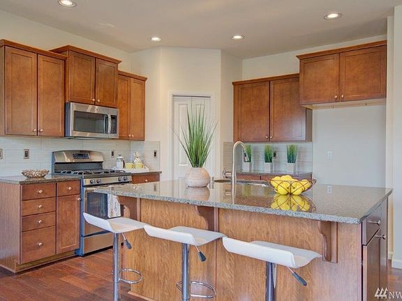 Kitchen with large island granite counter and stainless appliances