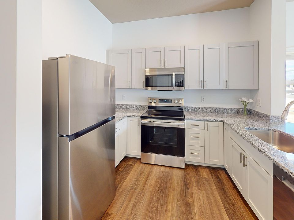 The Jane kitchen opens to the living room, and features granite countertops and stainless steel appliances, including a microwave and dishwasher.
