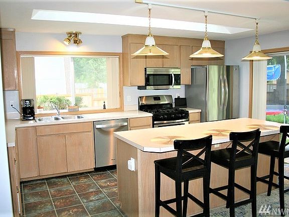 Bright Open Kitchen, Newer SS Appliances All Stay, Breakfast Bar Island, Skylight and Slider To The Back Yard. With Open Concept You Can See Everything.