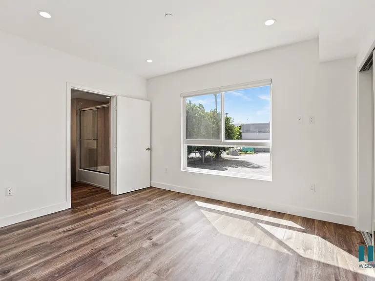 Bedroom with Large Windows, Bathroom, and Mirrored Closet