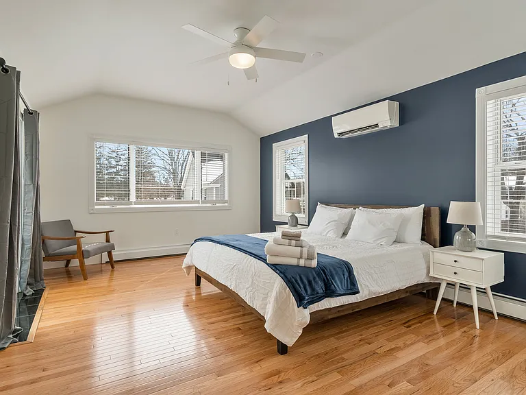 Bedroom, King Size Bed, Mini-Split AC, Natural Light, Large Windows, Modern Lighting, Hardwood Floors.