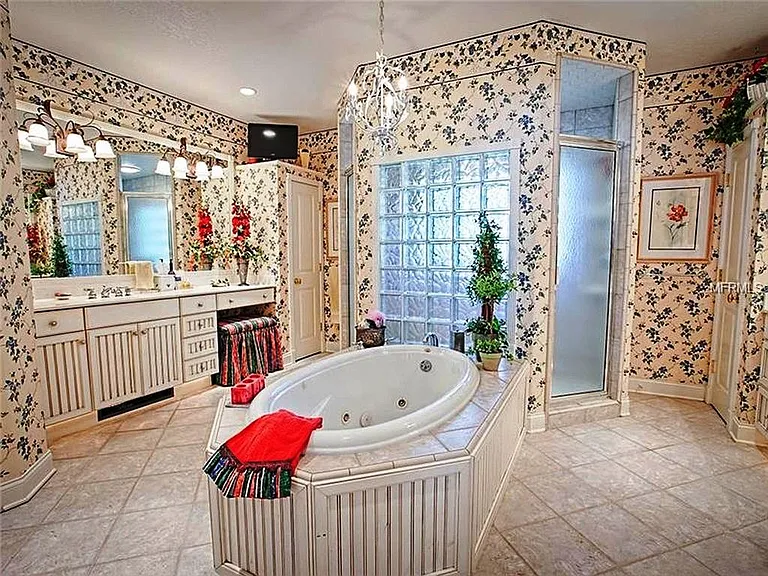 NOTE: the wallpaper has been removed and repainted with a beautiful linen white. The jacuzzi tub is next to a double head shower which has privacy glass overlooking the wrap around porch and front yard.