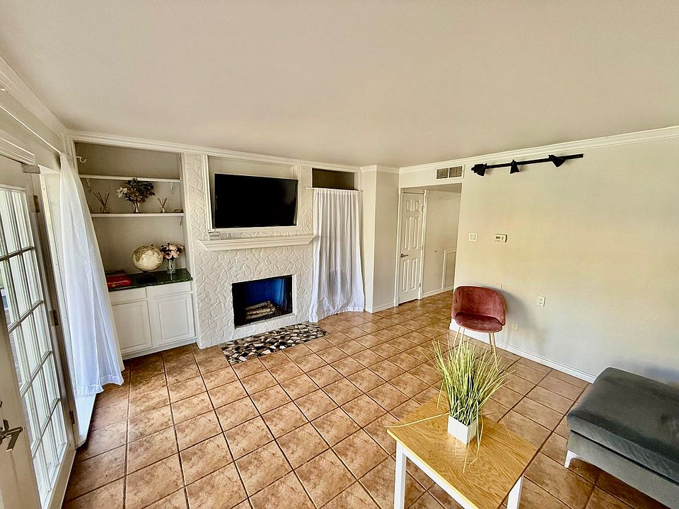 Living room has fire place and built in cabinets
