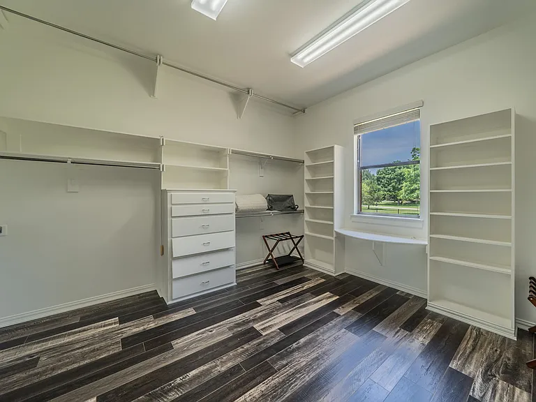 Spacious walk-in closet with custom shelving, drawer storage, and plenty of hanging space.
