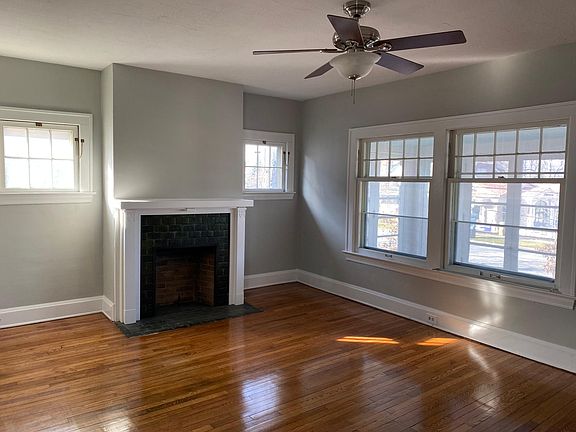 Living room has oak floors and decorative fireplace. Plenty of light in the living room.