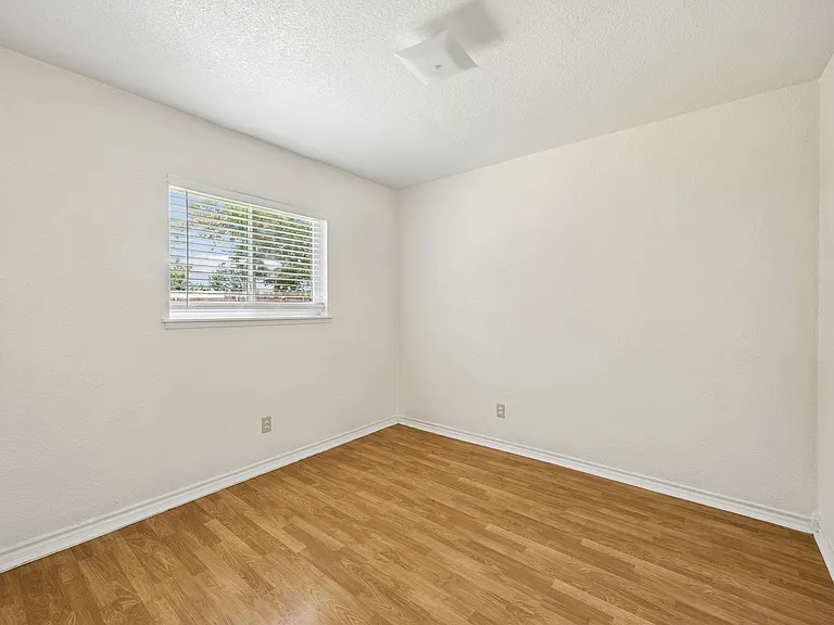 Room featuring wood-finish flooring, white baseboards, and neutral wall paint