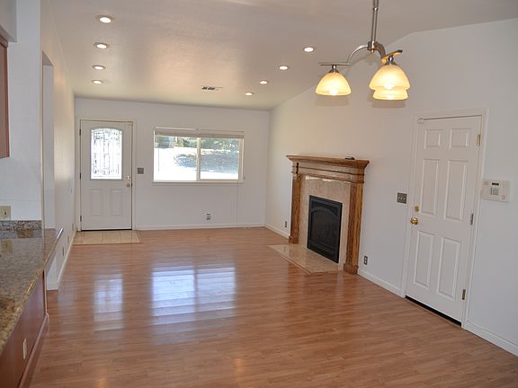 Large living room with gas fireplace, vaulted ceiling and recessed lighting.