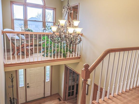 Curved solid oak staircase with white spindles. Sitting Room open to foyer with large window reflecting lots of sunlight.