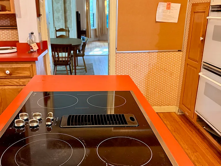 Kitchen stovetop & ovens, looking into dining & living room.