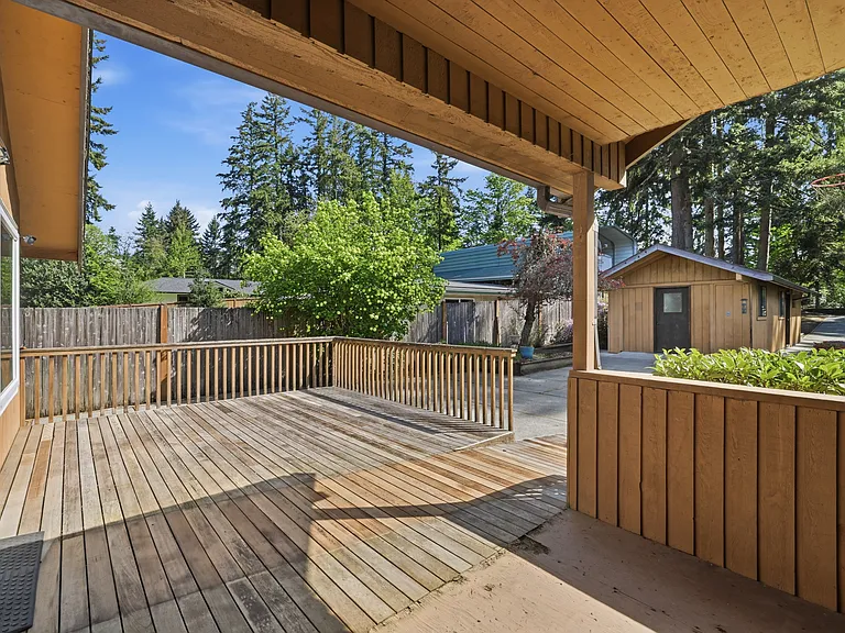 Covered deck overlooking the yard and finished outbuilding