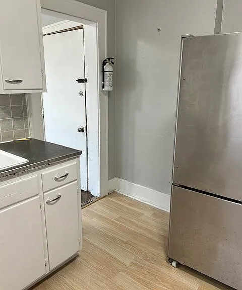 The door is the entrance from the exterior stairwell. It enters into a small porch with all windows and wood floors.