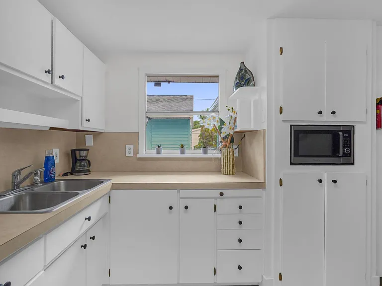 Functional kitchen with ample cabinet storage, generous counter space, and a window over the sink for natural light.
