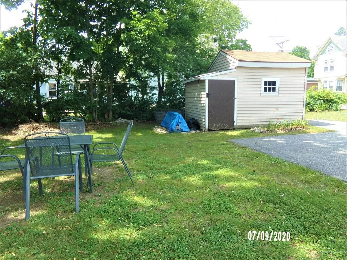 Backyard with tarred parking area. Small shed for rakes, shovels, and mower. - 815 Main St #A