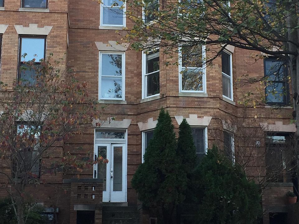 Row house front photo. Steps up to main door. Above ground apartment is at front door level.