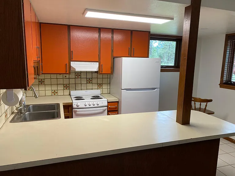 Another view of the kitchen with the refrigerator and the large serving bar.