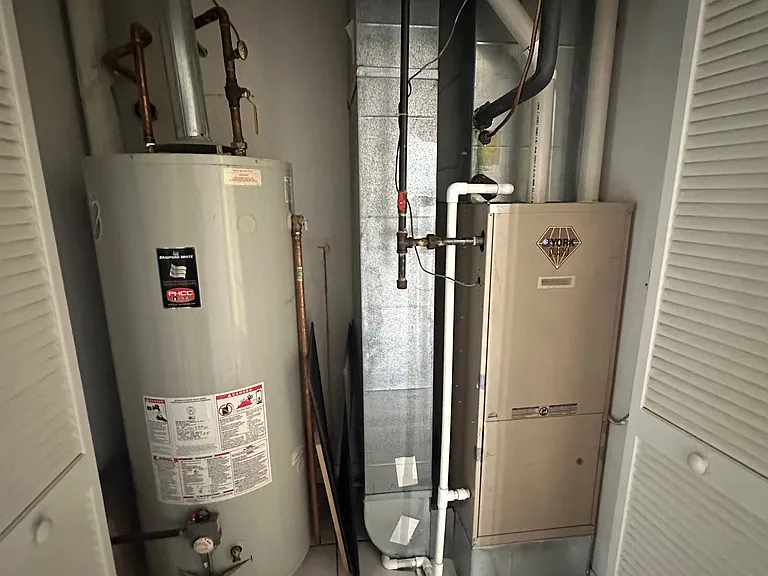 Hot-Water Tank and Furnace in Hallway across from Storage Closet