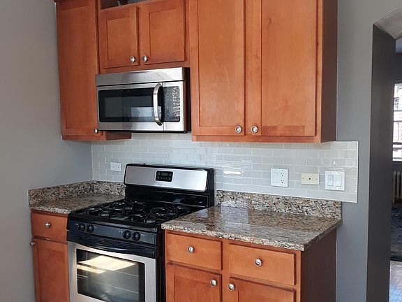 Cherry cabinets; glass tile, stainless steel appliances.