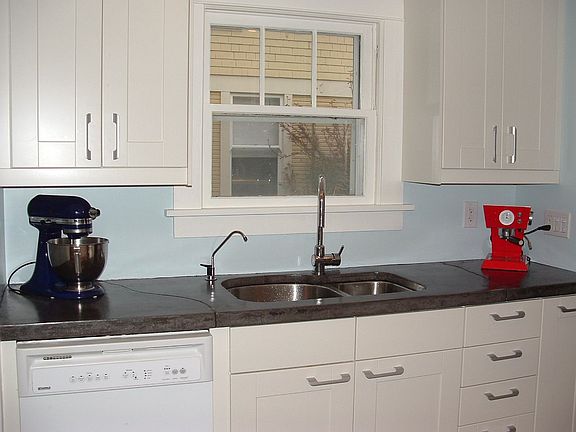 Kitchen sleek and efficient featuring Ikea cabinets and concrete counters.