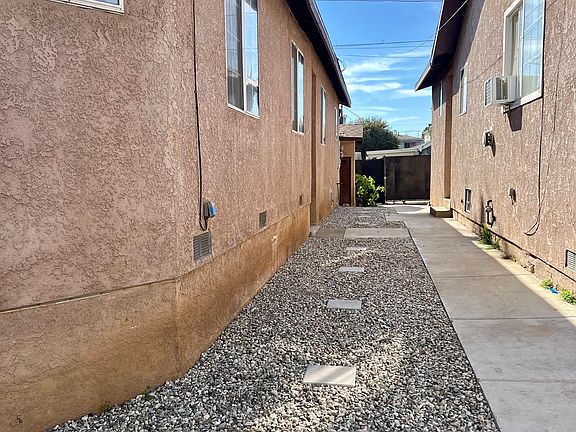 The house to the left is the one that is being rented. The walkway has cement with pebble rocks and stepping blocks. The second door entrance is in the center.