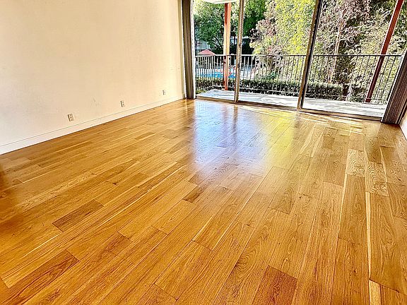 Unit #103 huge living room with hardwood floors overlooking the pool! Picturesque and private!