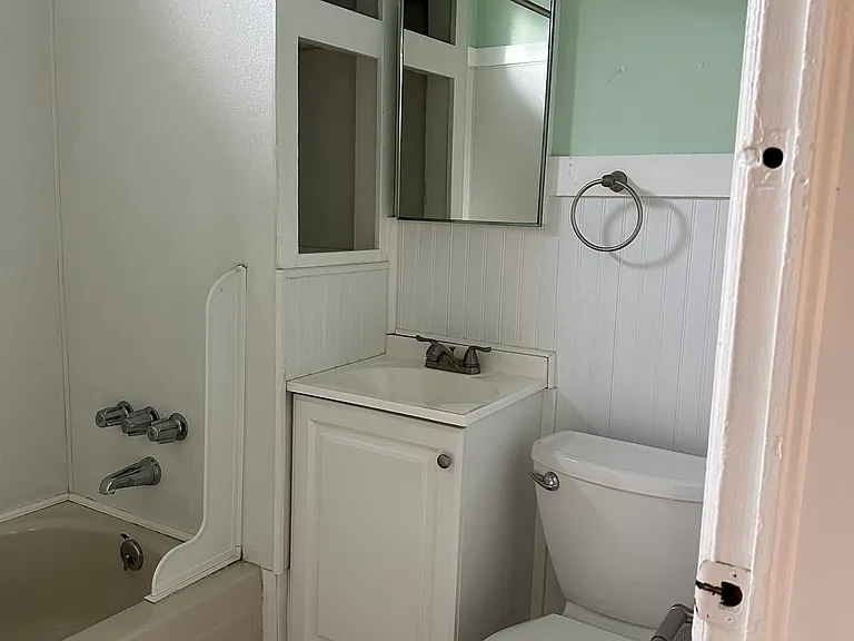 Adorable and efficient bathroom with full shower/tub.