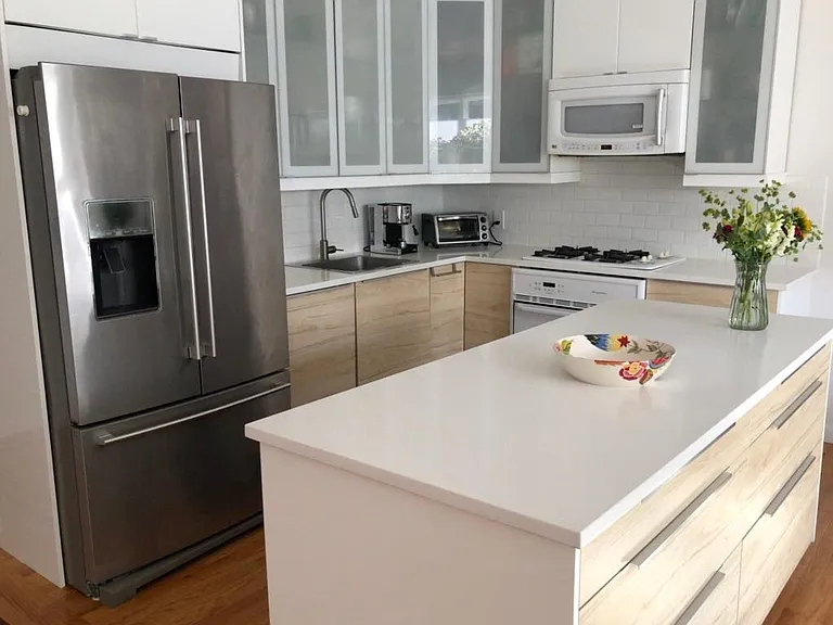 The island is on casters and can be moved to expand or tighten the kitchen work area. Storage is on both sides of the island.