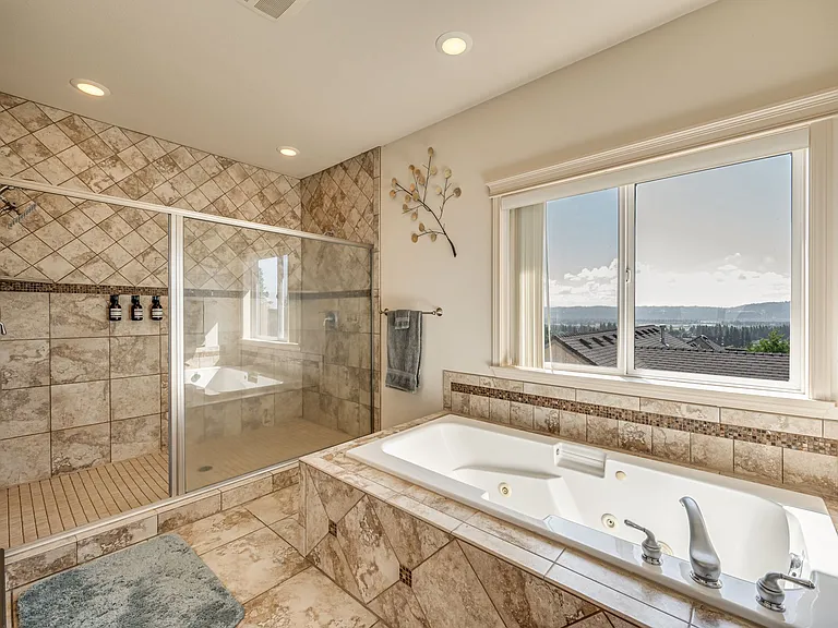 Featuring double sinks, separate water closet, double shower, and soaker tub