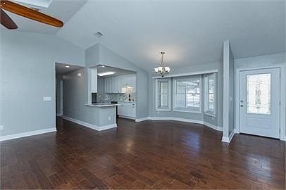 View of kitchen, dining area, and entry from living area