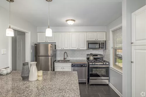 Kitchen with granite countertops and stainless steel appliances. - The Wynnewood