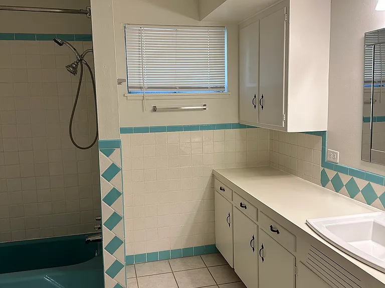 Main bathroom features a shower/tub combination and ample storage.