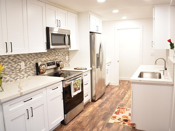 Kitchen with brand new Shaker cabinets, Quartz countertops, tiled backsplashs and stainless steel appliances.