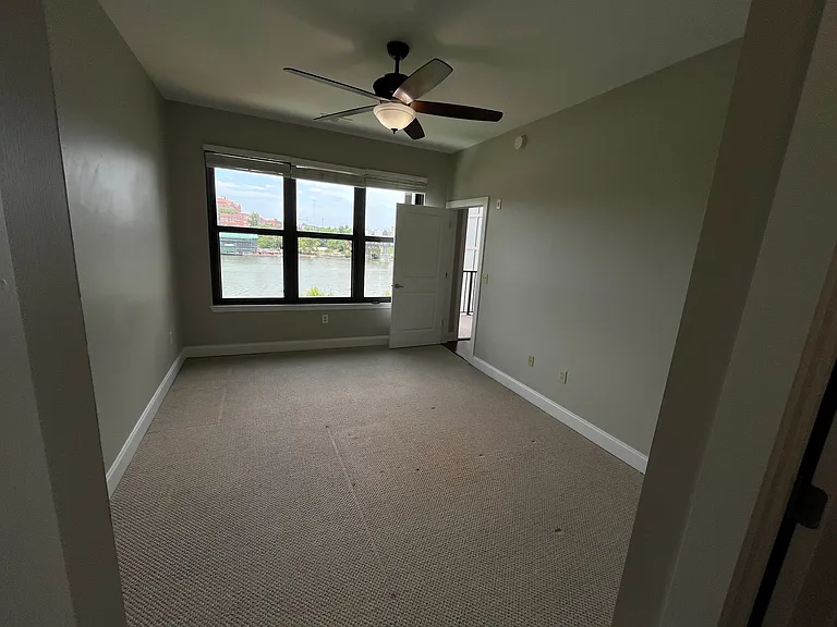 Unfurnished bedroom with a peaceful view of the Tennessee River from the left-side window, offering abundant natural light and a relaxing setting.