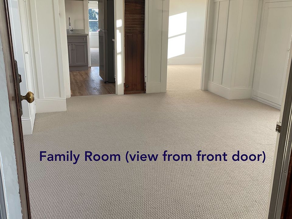 Family room view from the front door looking into a bedroom and the kitchen
